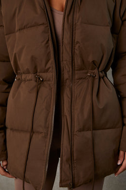 Abrigo acolchado con capucha de largo medio en color marrón cacao
