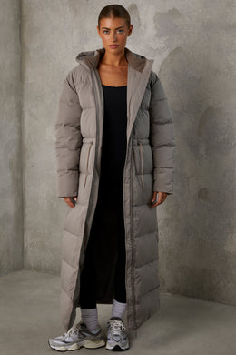 Abrigo acolchado largo con capucha en gris cálido