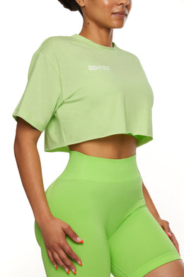 Side view of cropped T-shirt in green with biker shorts